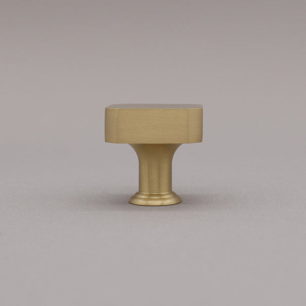 Satin brass gold square knob on gray background