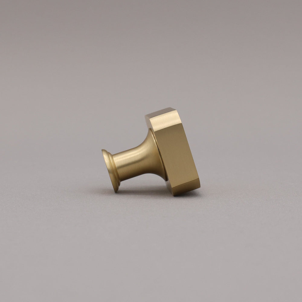 Satin brass gold square knob on gray background