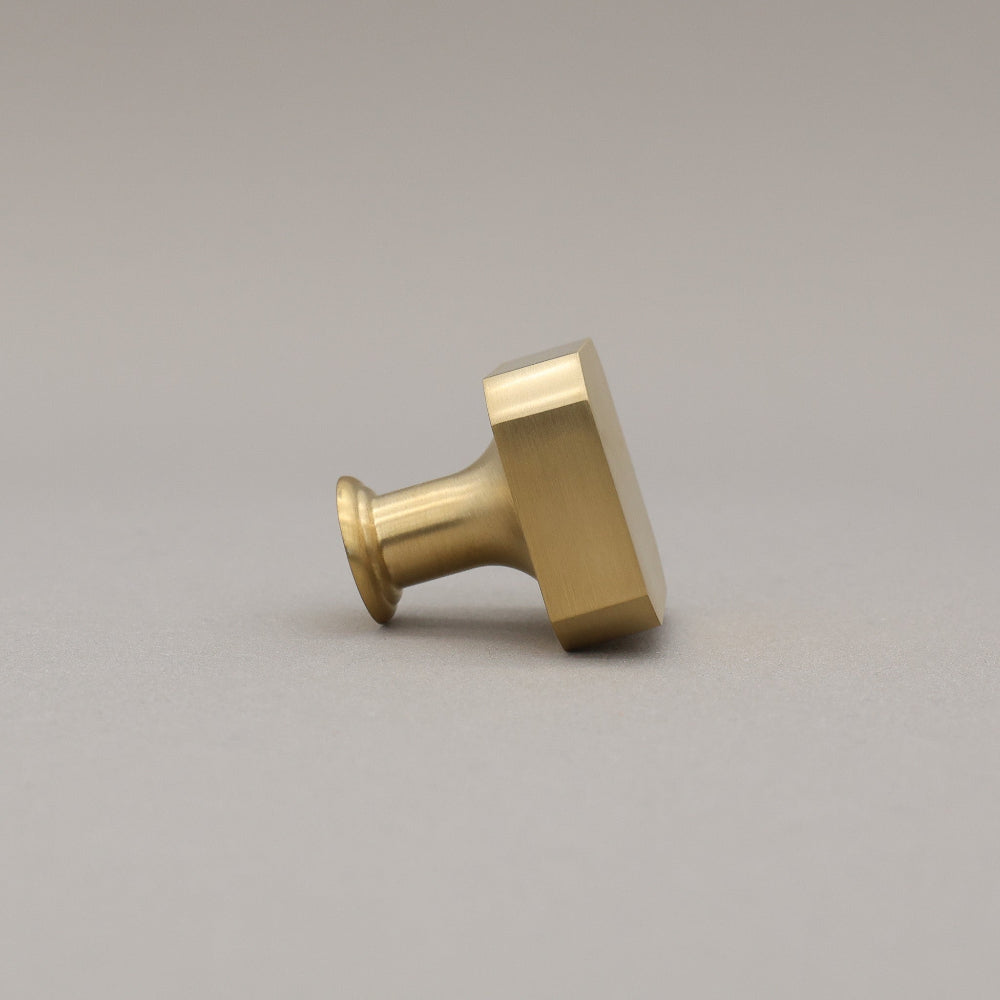 unlacquered satin brass gold square knob on gray background