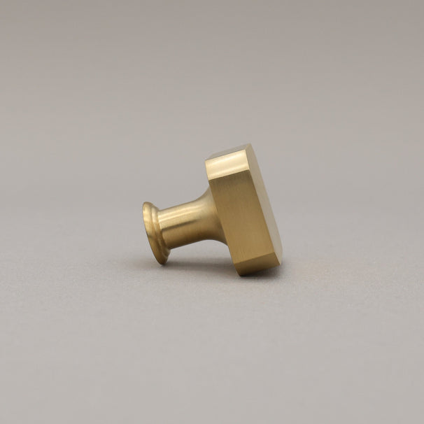 unlacquered satin brass gold square knob on gray background