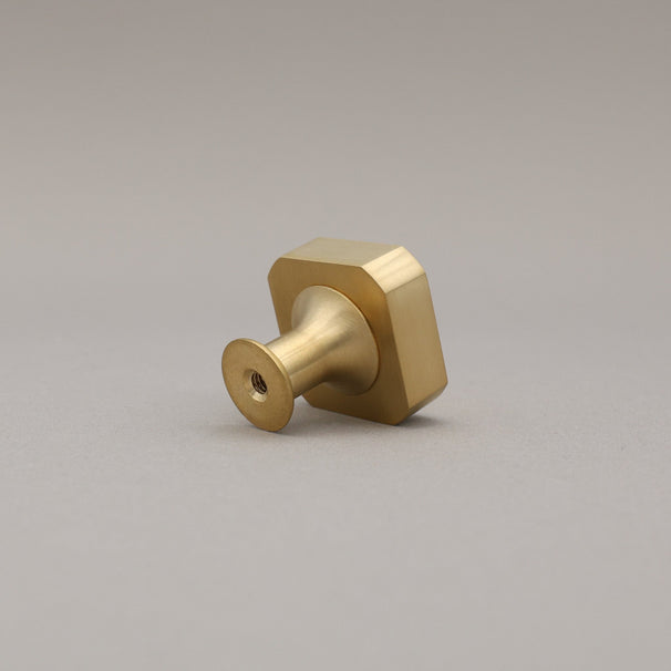 unlacquered satin brass gold square knob on gray background