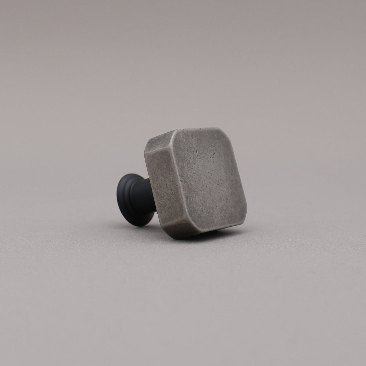 weathered nickel silver and matte black two tone square mod knob on gray background