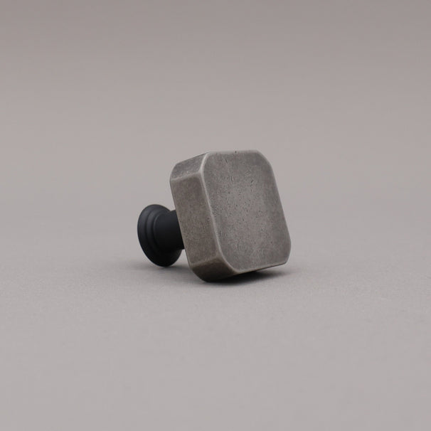 weathered nickel silver and matte black two tone square mod knob on gray background