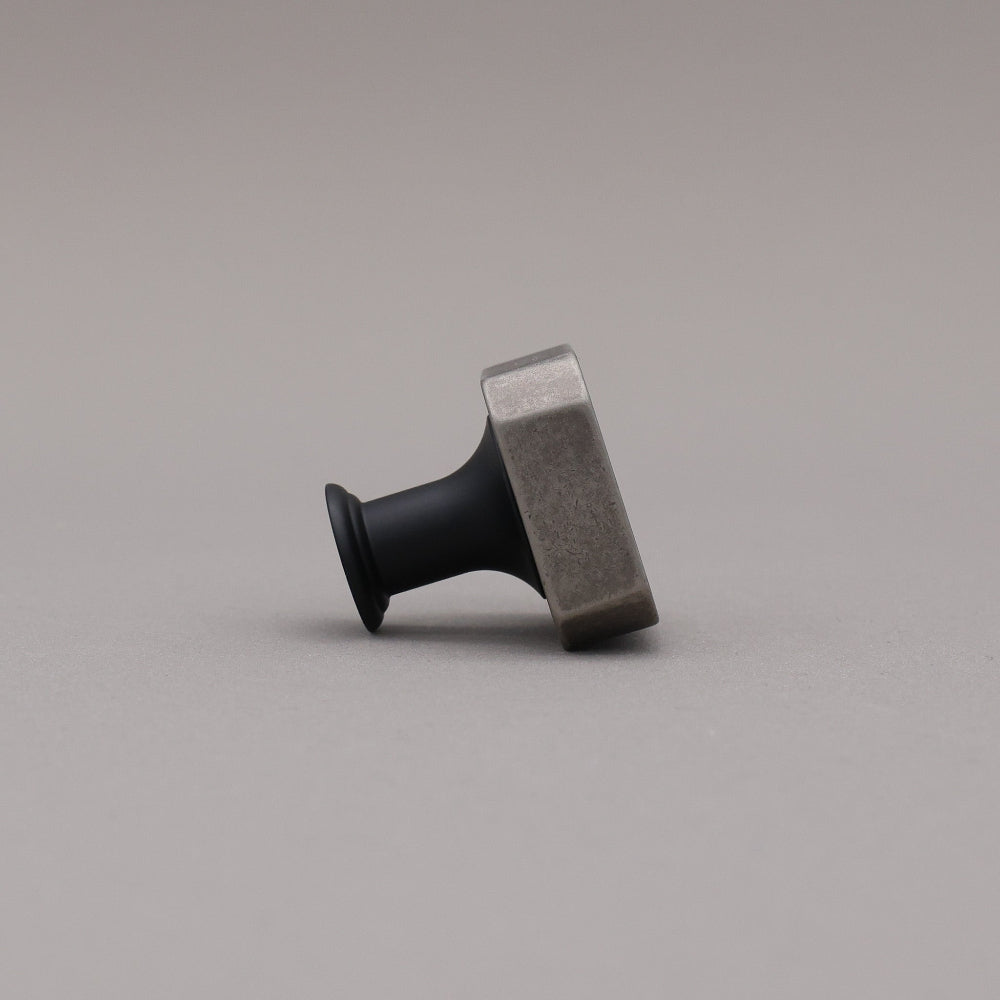 Weathered nickel and matte black two tone square knob on gray background