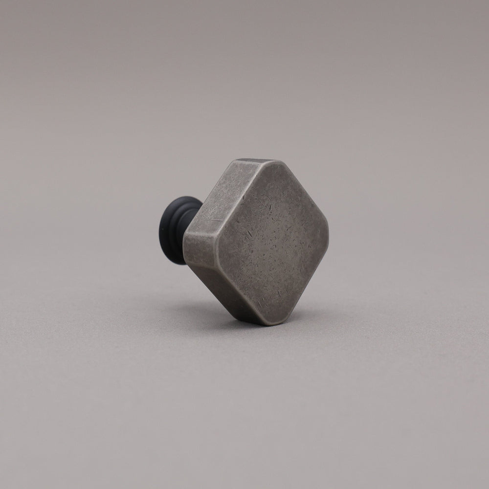 Weathered nickel and matte black two tone square knob on gray background