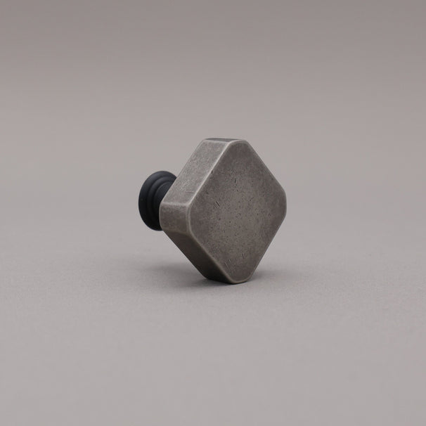Weathered nickel and matte black two tone square knob on gray background