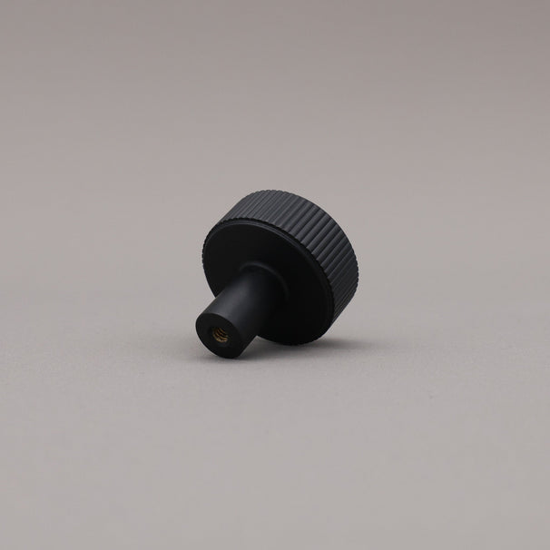 Black textured knob on a gray background