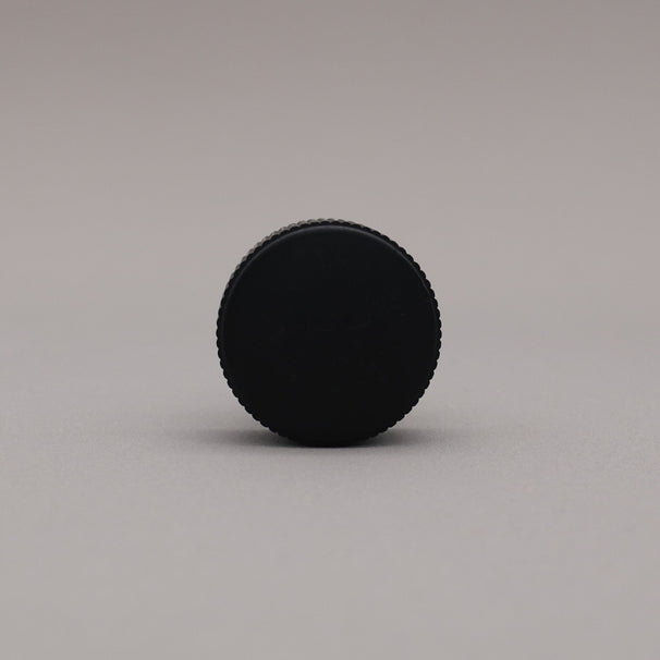 Black circular knob on a gray background