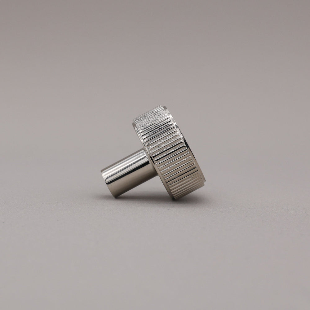 polished nickel textured ribbed knob with fluting detail on a gray background