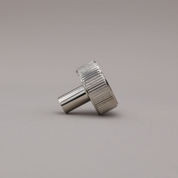 polished nickel textured ribbed knob with fluting detail on a gray background