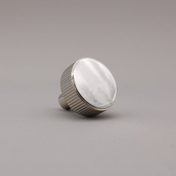 polished nickel textured ribbed knob with fluting detail on a gray background