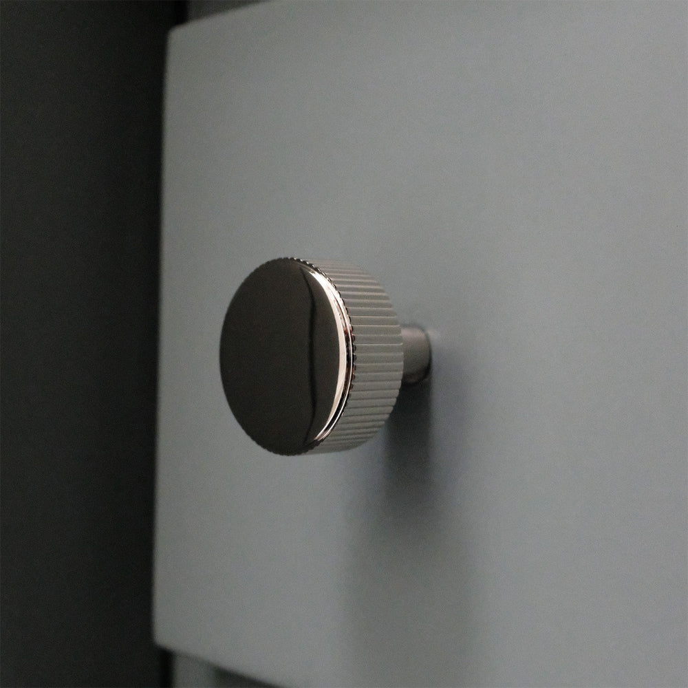Ribbed Polished Nickel Knob on blue bathroom cabinet drawer.