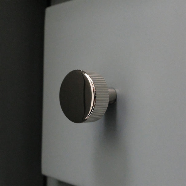 Ribbed Polished Nickel Knob on blue bathroom cabinet drawer.