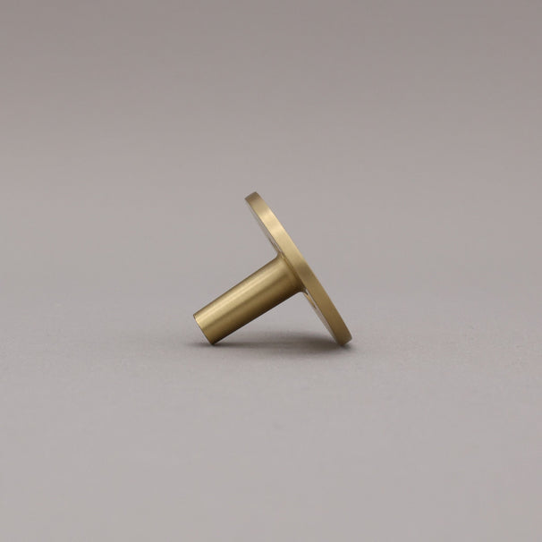 Side view of satin brass smile knob.