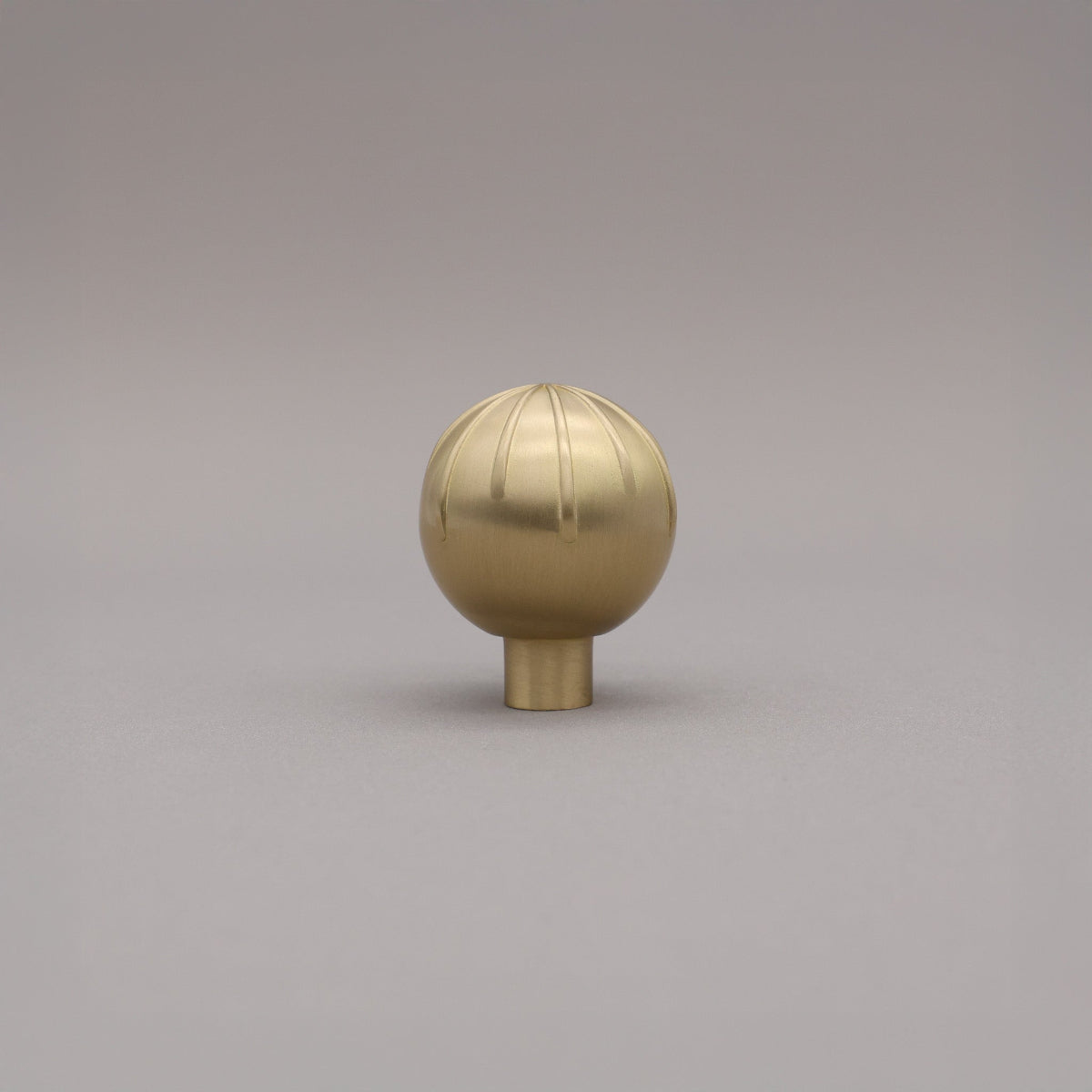 Round sunburst knob satin brass gold on gray background