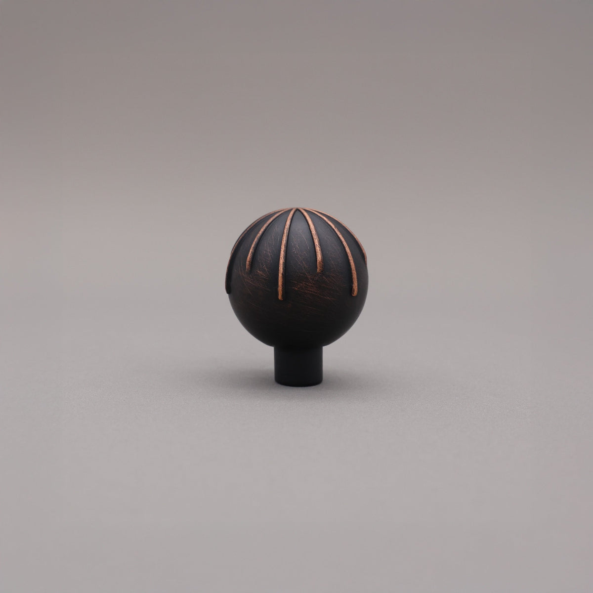 Round sunburst knob venetian bronze with copper on gray background
