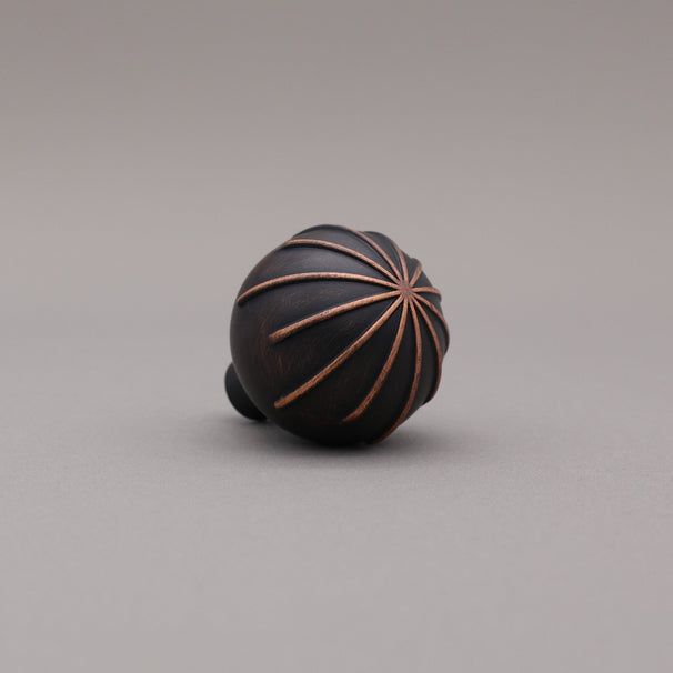Venetian Bronze round sunburst knob at angle.