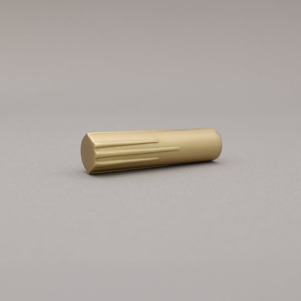 Sunburst t-knob in satin brass gold on a gray background