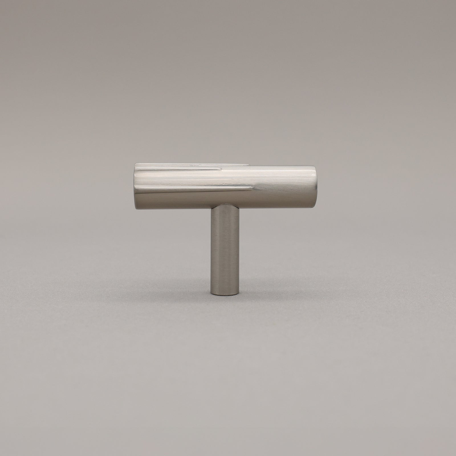 Satin Nickel art deco knob on a gray background.