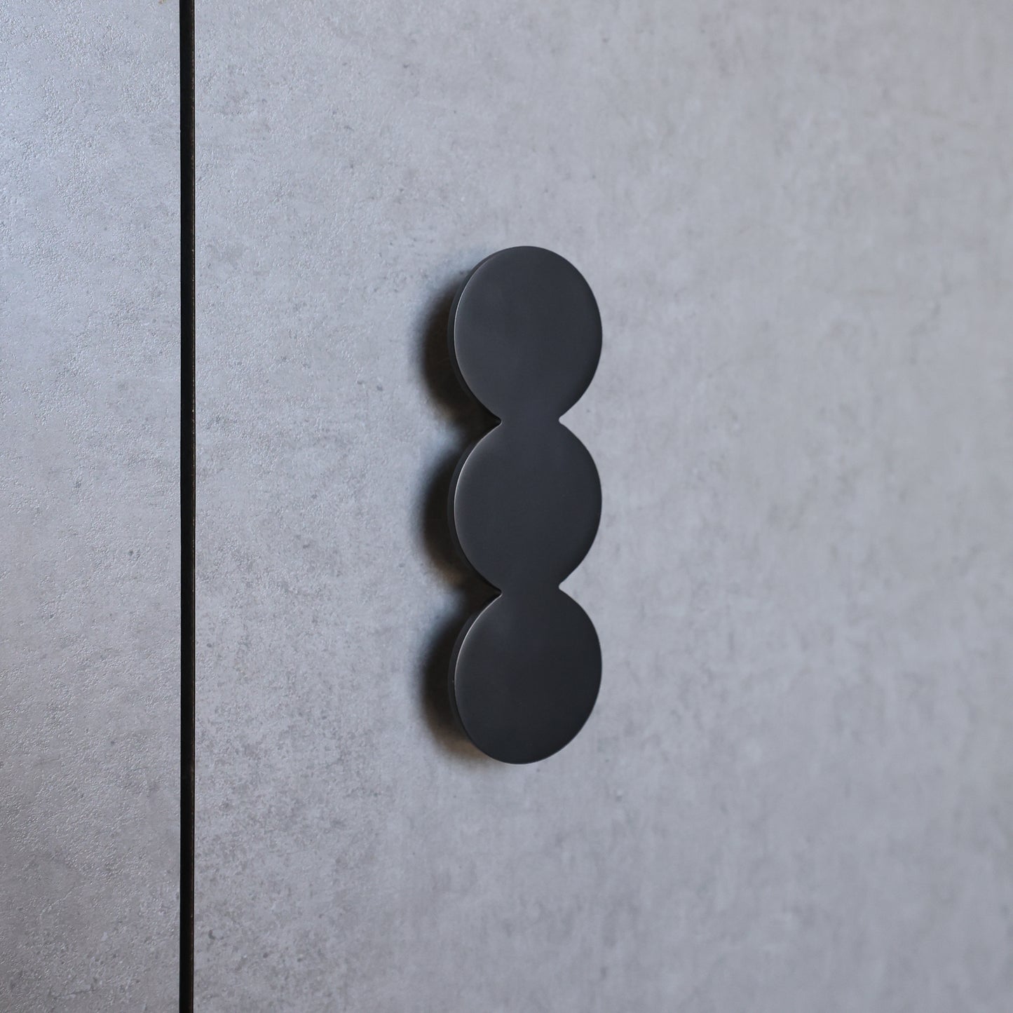 Black three-circle design on a gray textured surface