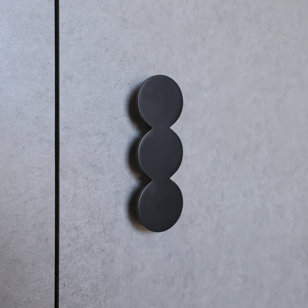 Black three-circle design on a gray textured surface