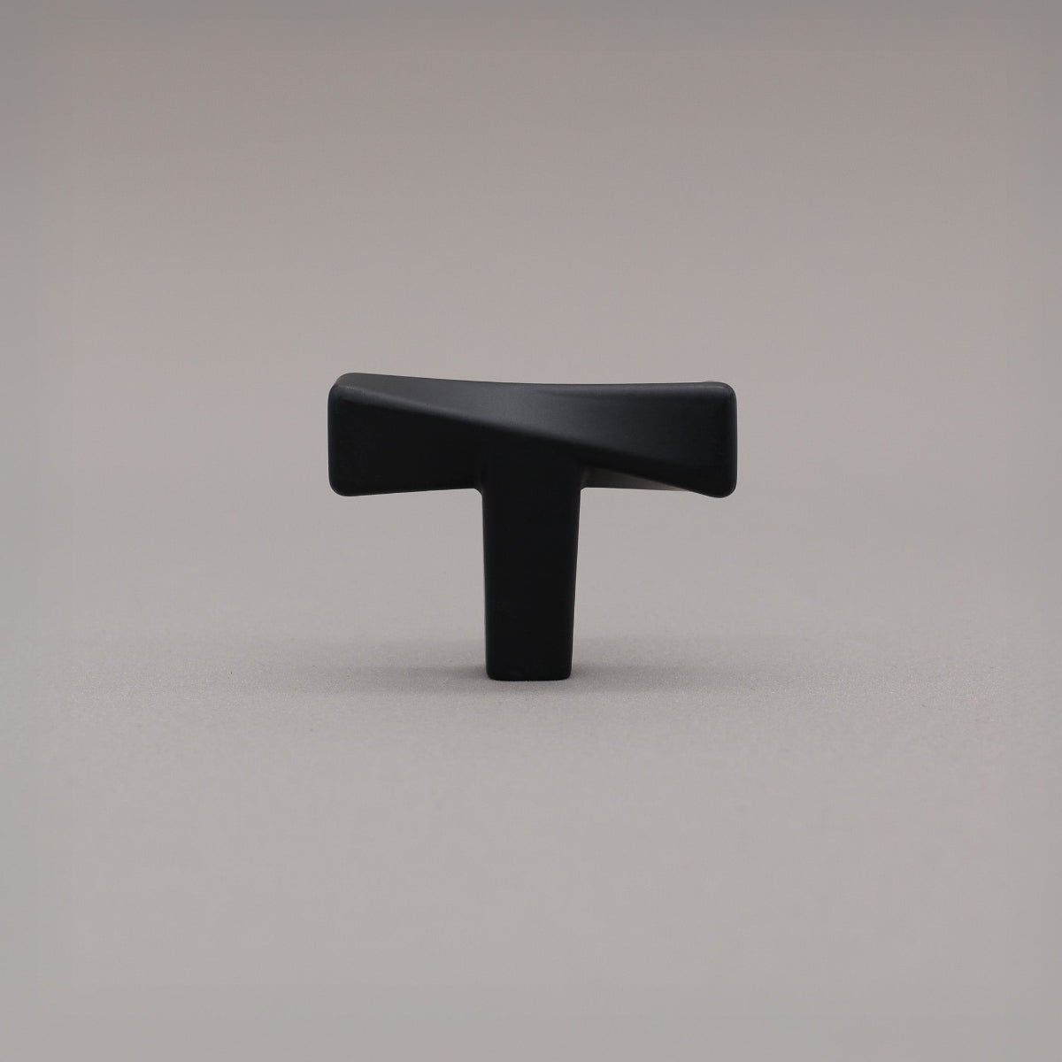 Black cabinet knob on a gray background