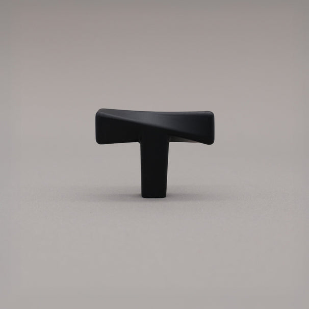 Black cabinet knob on a gray background