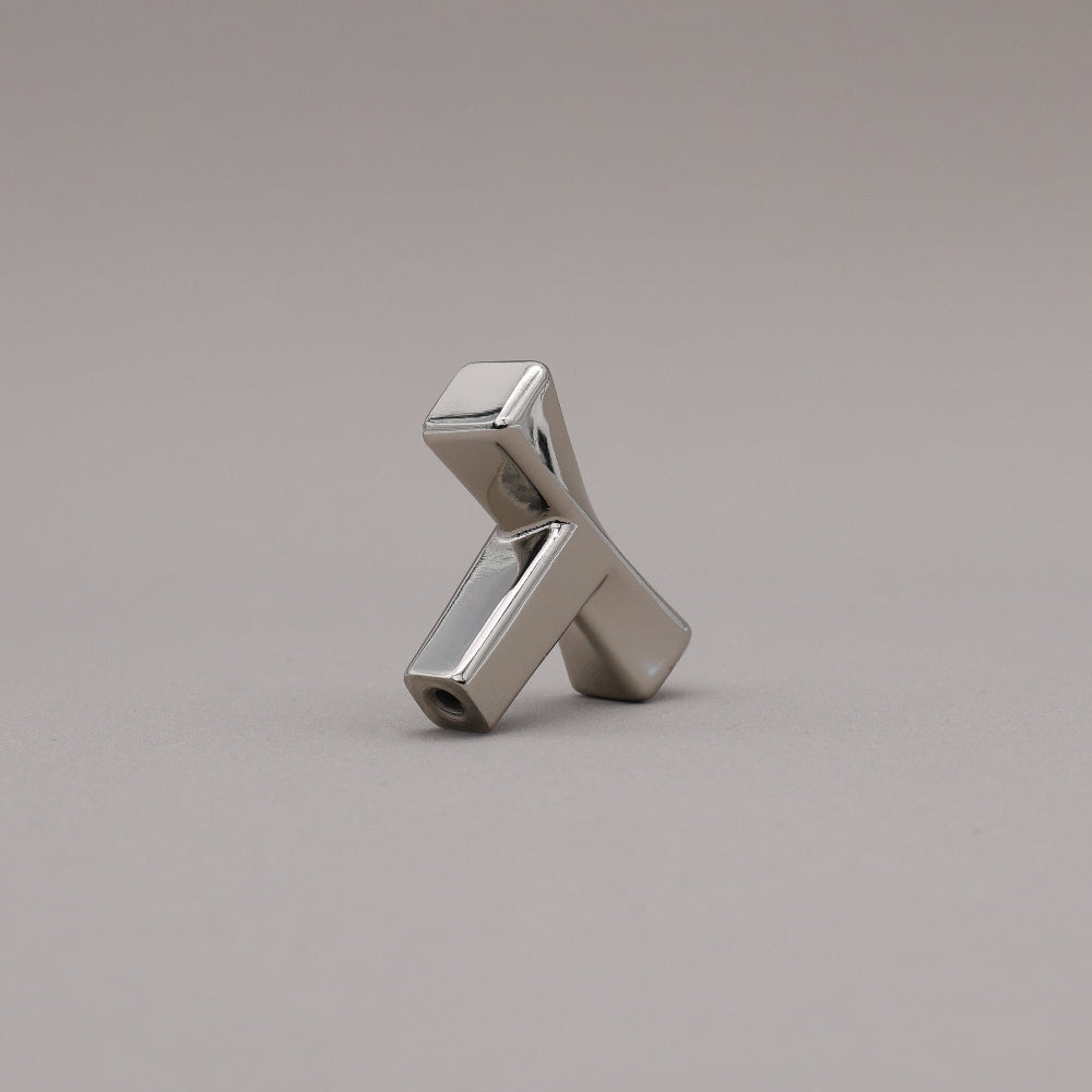 Polished nickel finished twist cabinet knob on gray background.