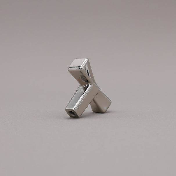 Polished nickel finished twist cabinet knob on gray background.