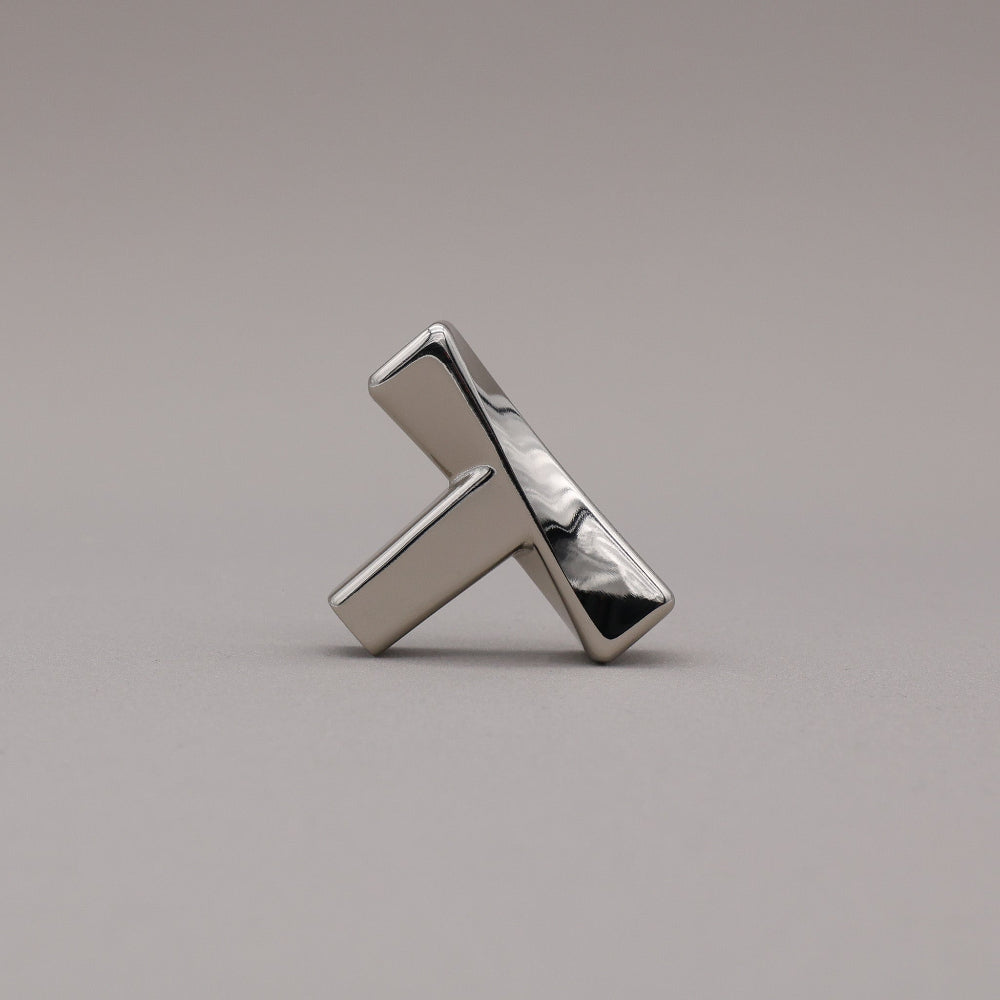 Polished nickel finished twist cabinet knob on gray background.