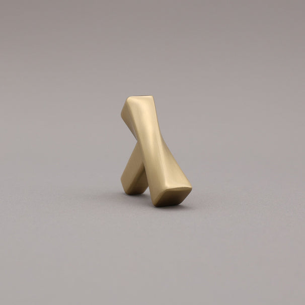 Satin Brass twisted knob on a gray background leaning forward angled.