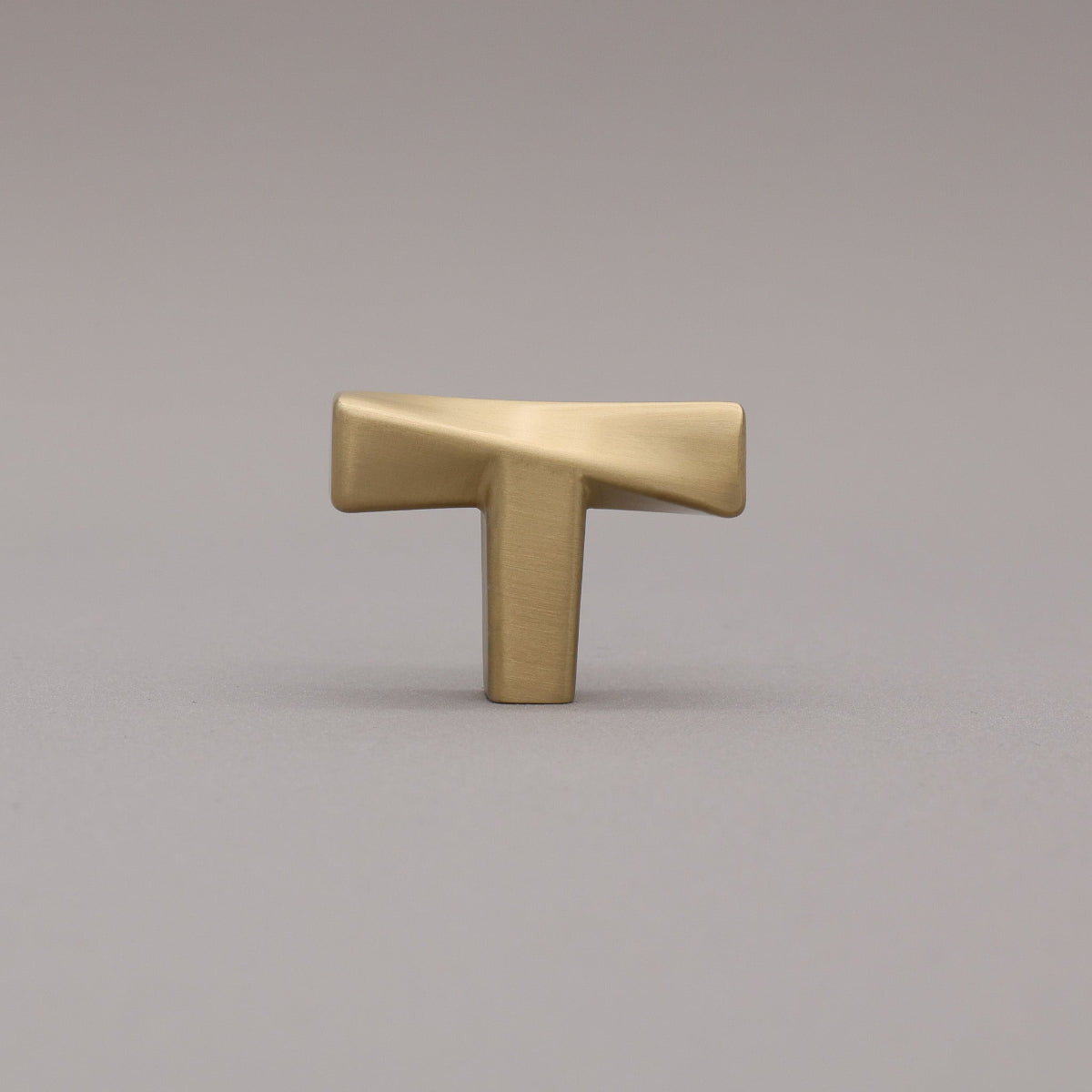 Satin Brass twist Knob on a gray background