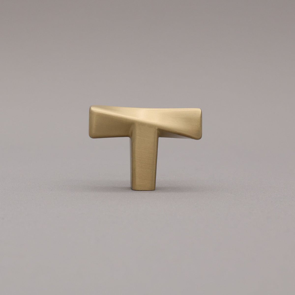 Satin Brass twist Knob on a gray background.