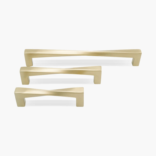 Set of three twisted satin brass cabinet pulls on white background