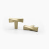 Two Satin Brass Hapny Twist t-knobs, one standing and one front-facing while laying down