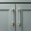 Two Clarity 5" center to center cabinet pulls in Clear Acrylic and Satin Brass installed on blue cabinet doors