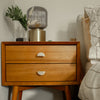 Two Half Moon Satin Brass cabinet knobs installed on a light brown sidetable