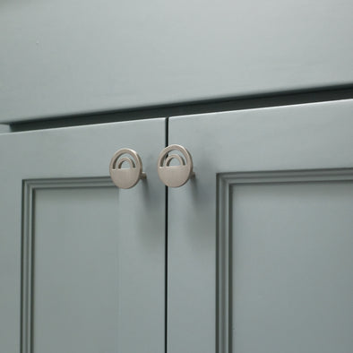 Two Matte Black Hapny Horizon knobs, one standing and one front-facing while laying down