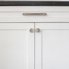 One 8" Hapny Horizon cabinet pull and two Horizon knobs in Satin Nickel installed on white cabinet doors and drawers