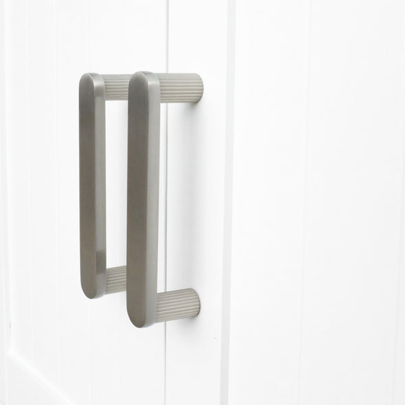 Two 96mm Hapny Ribbed cabinet pulls in a Satin Nickel finish installed on white doors