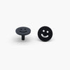Two Matte Black Smiley knobs, one standing and one front-facing while laying down