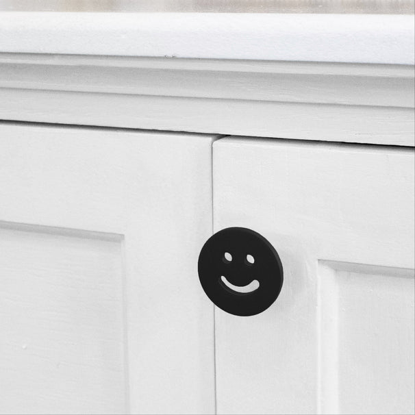 Matte Black Smiley knob installed on a white cabinet door