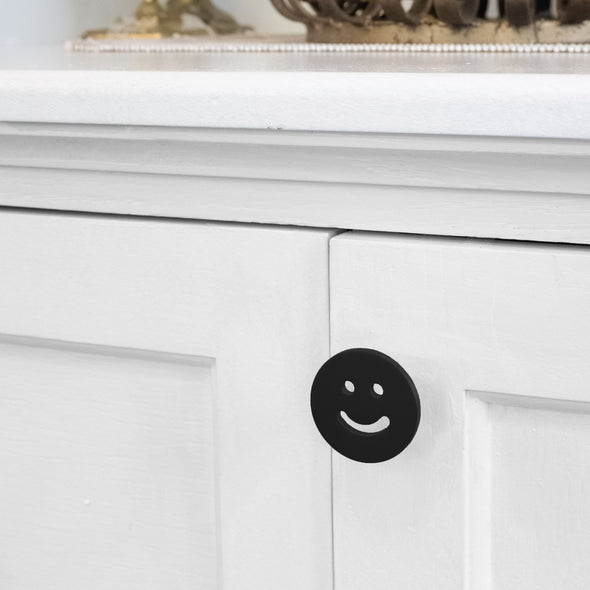 Matte Black Smiley knob installed on a white cabinet door
