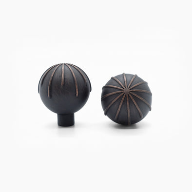 Two Venetian Bronze Hapny Sunburst knobs, one standing and one front-facing while laying down