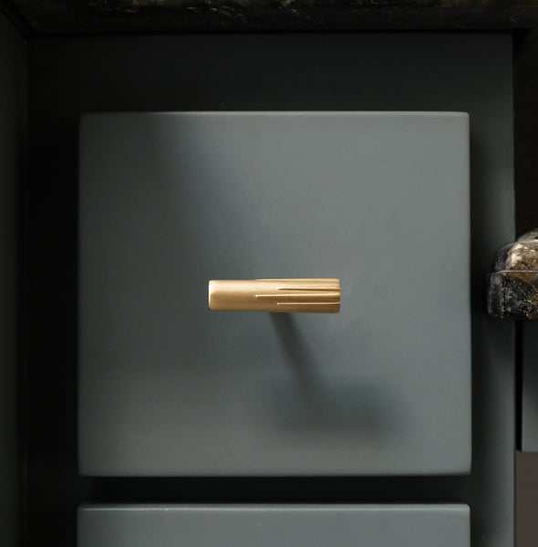 Hapny Sunburst t-knob in Satin Brass finish installed on a blue square drawer