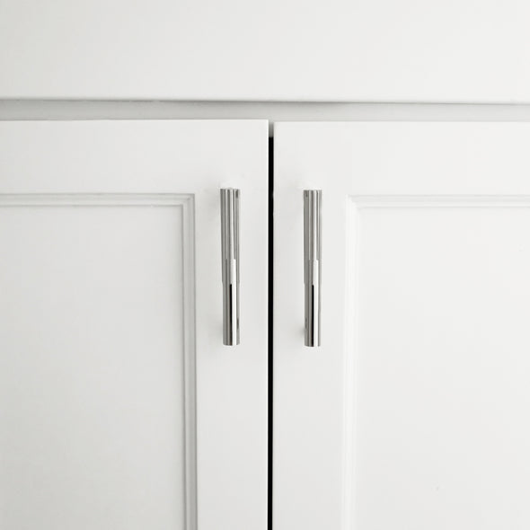 Two Polished Nickel Hapny Sunburst 4" cabinet pulls installed on white cabinet doors