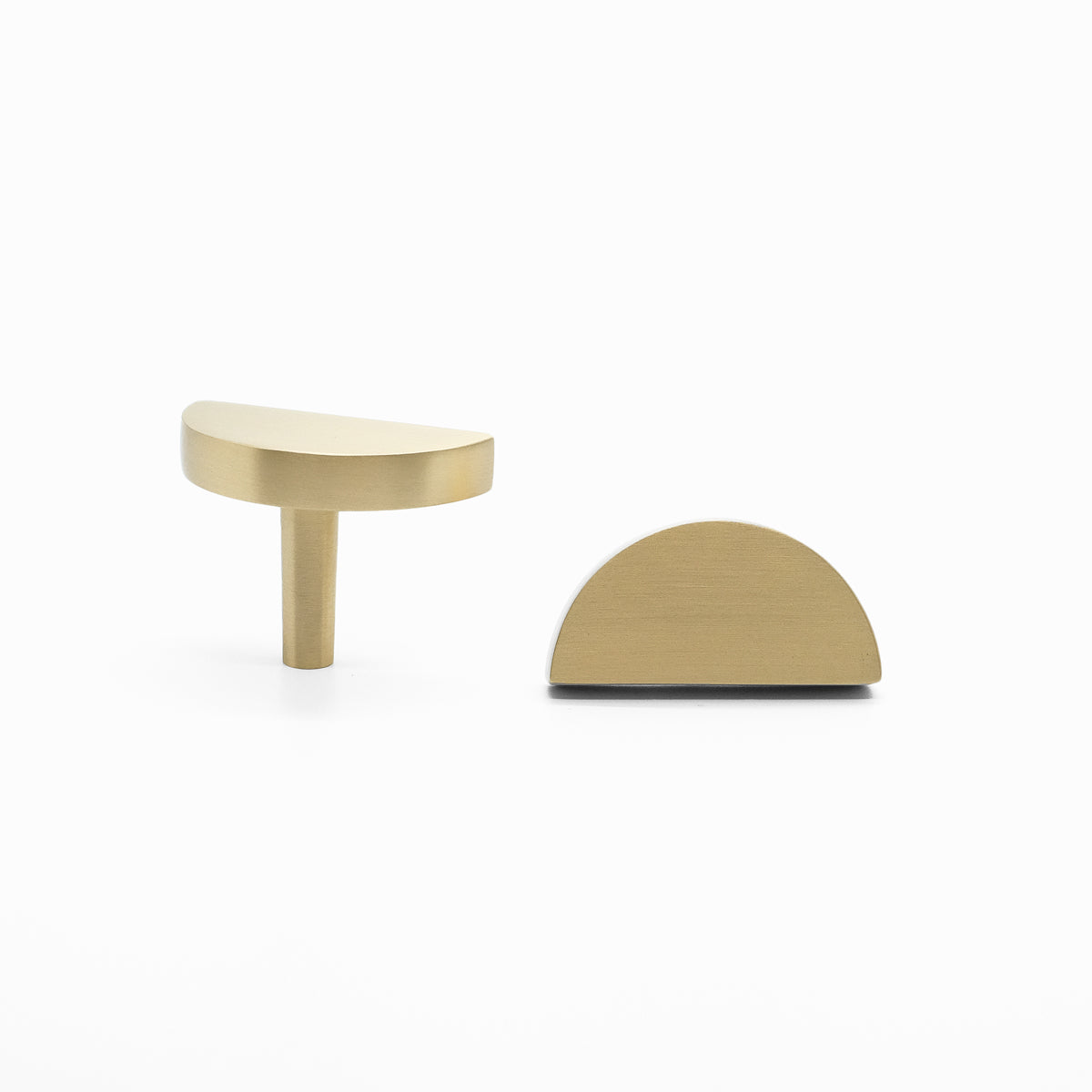 Two Satin Brass Half Moon cabinet knobs, one standing and one front-facing while laying down.